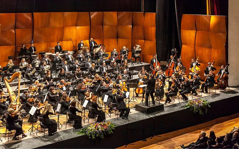 Context: A modern Malta Philharmonic Orchestra performance at the MCC.